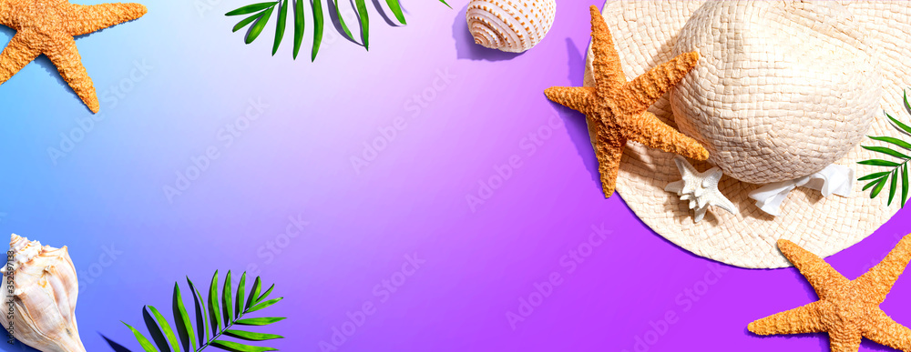 Summer concept with a straw hat and starfish overhead view - flat lay