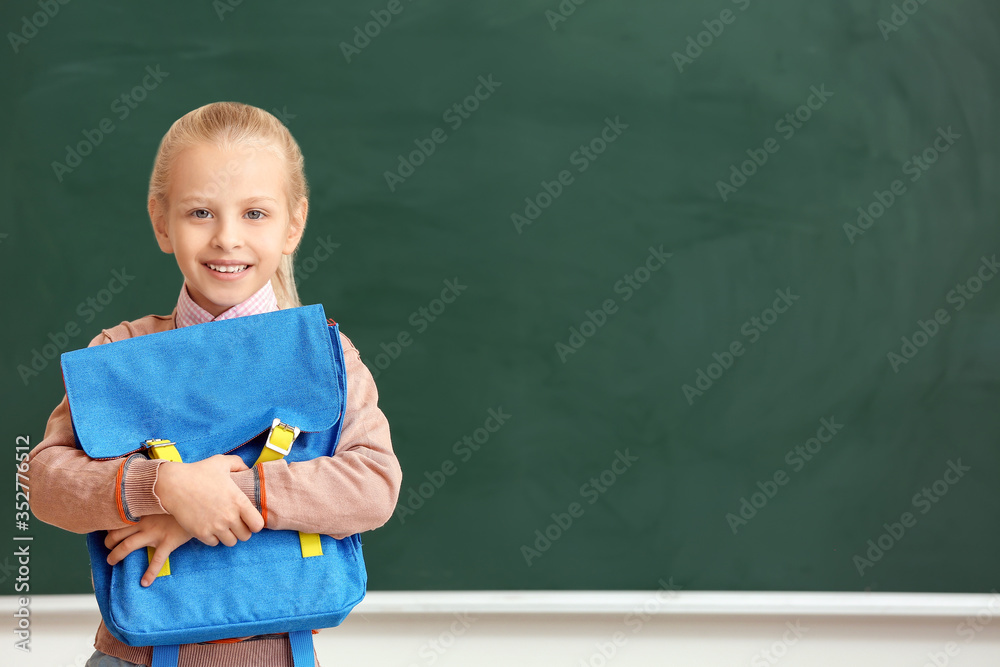 Cute little schoolgirl in classroom