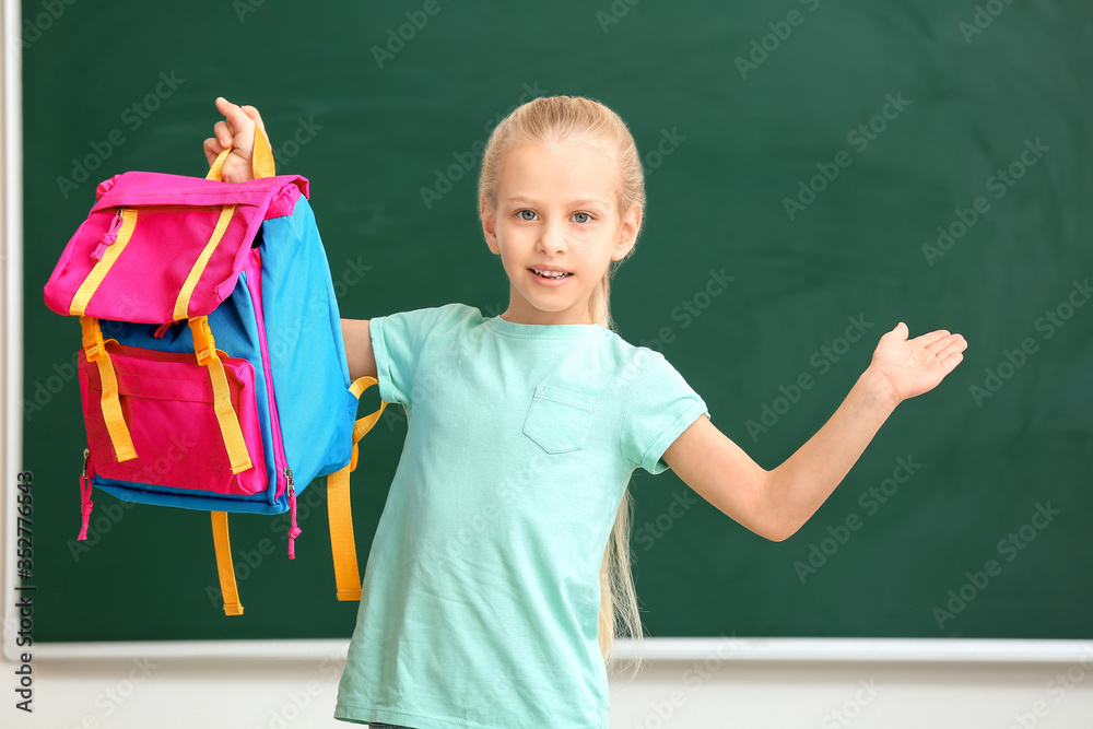 Cute little schoolgirl in classroom