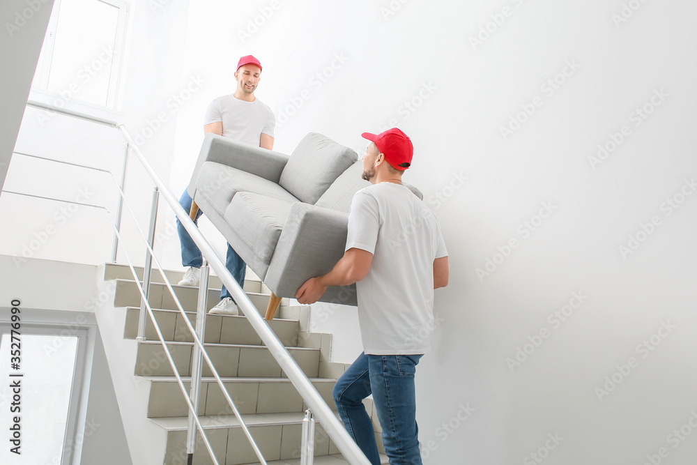 Loaders carrying furniture in the stairway