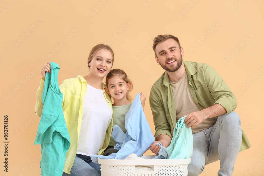 Family with laundry on color background