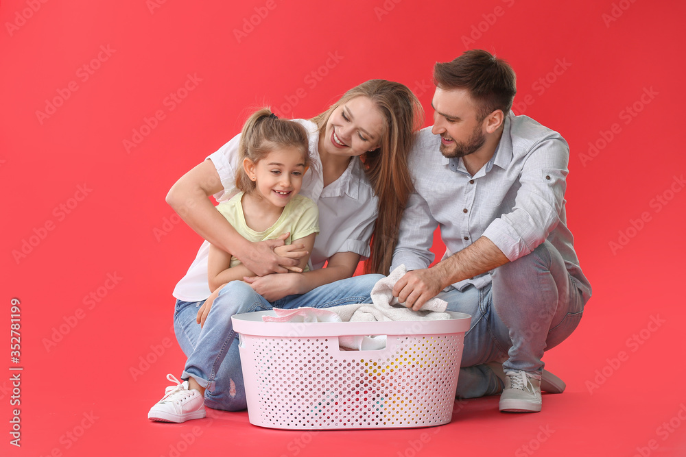 Family with laundry on color background