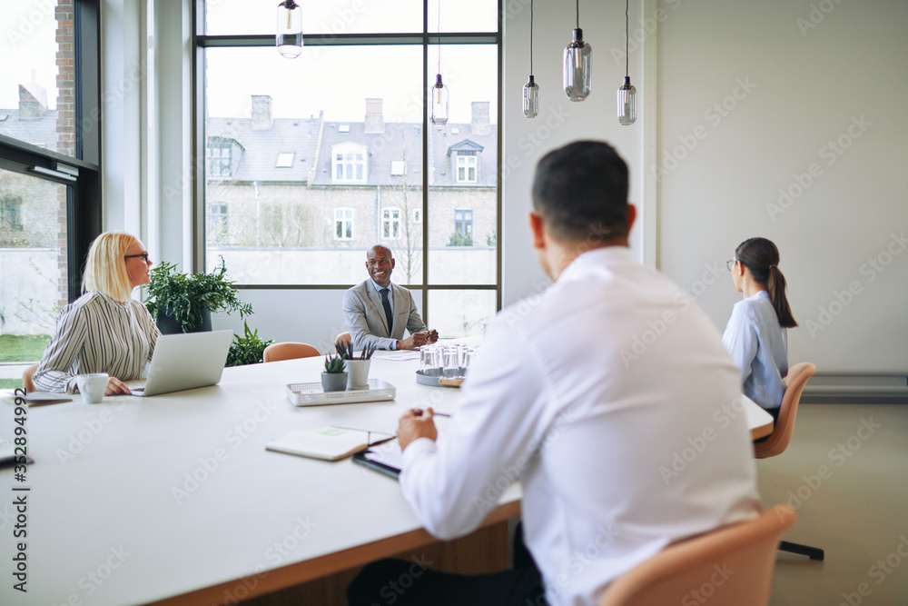 Diverse businesspeople smiling during a meeting around a boardro