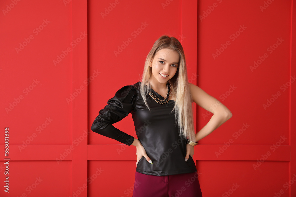 Beautiful young female dancer against color wall