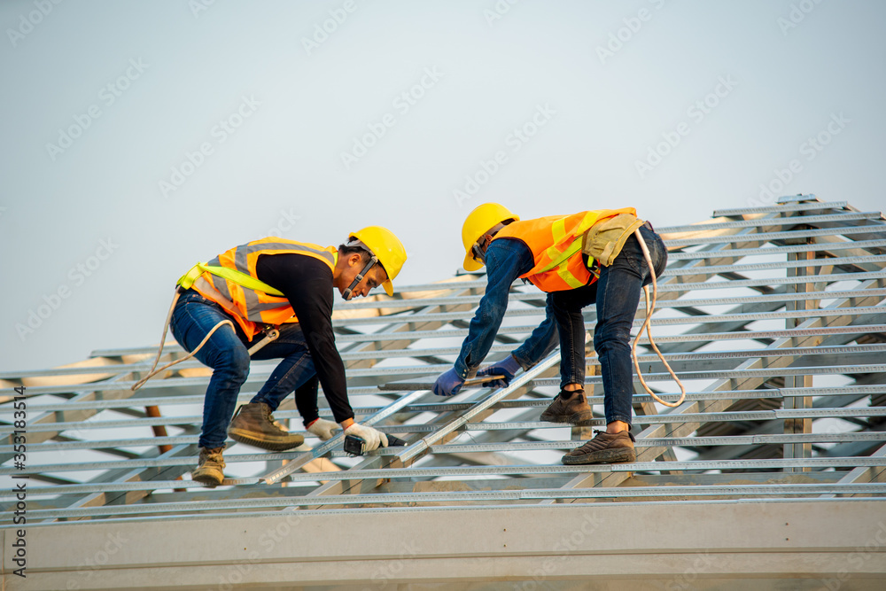 Handyman working on install the roof,Roofer builder working on roof structure of building on constru