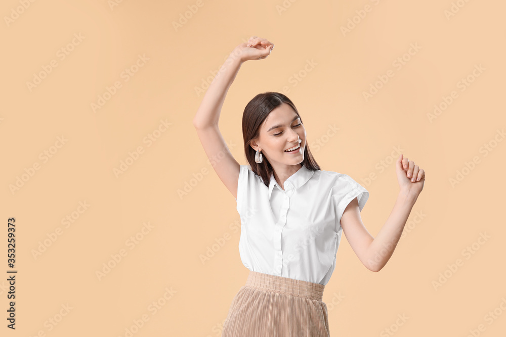 Beautiful young woman dancing against color background