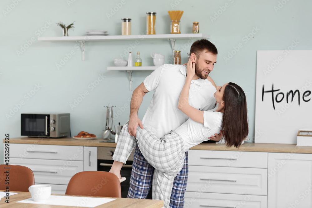 Happy young couple dancing in kitchen