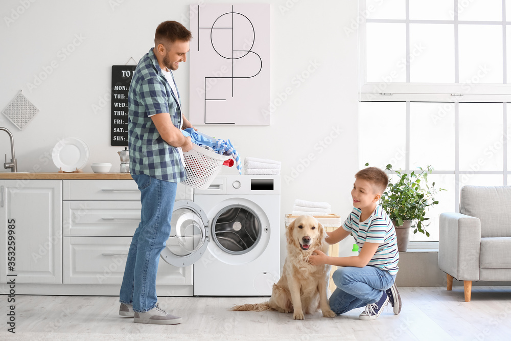 Man and his little son with cute dog doing laundry at home