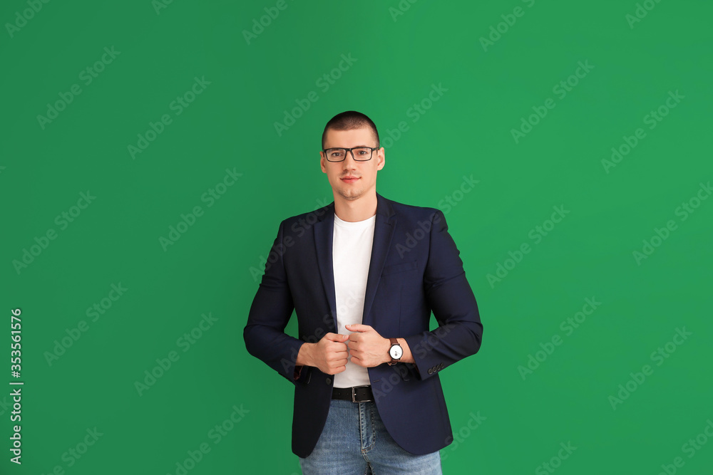 Handsome young man in stylish clothes on color background