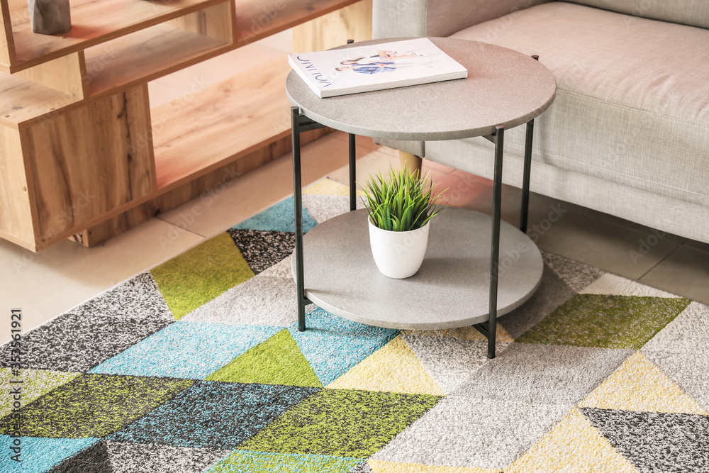 Stylish interior of living room with carpet and table