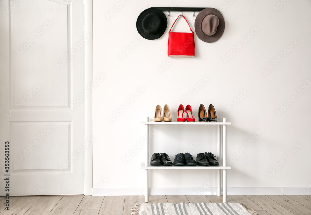 Stand with stylish shoes in interior of modern hall