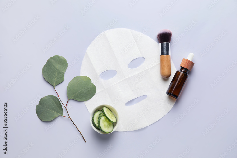 Composition with fabric facial mask, cosmetics and cucumber on white background