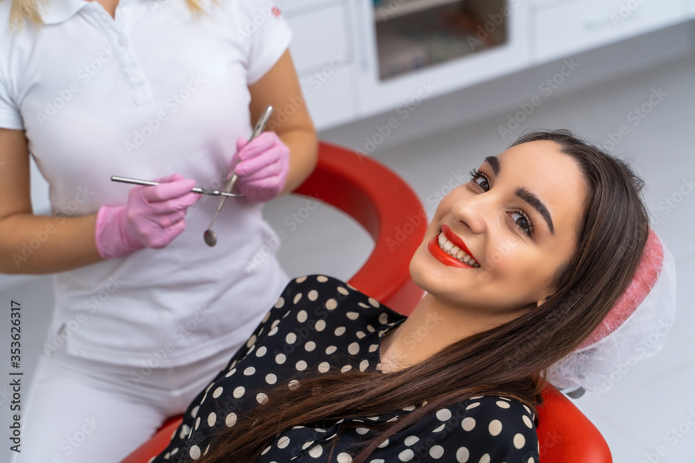 Young female patient visiting dentist office. Beautiful smiling woman with healthy straight white te