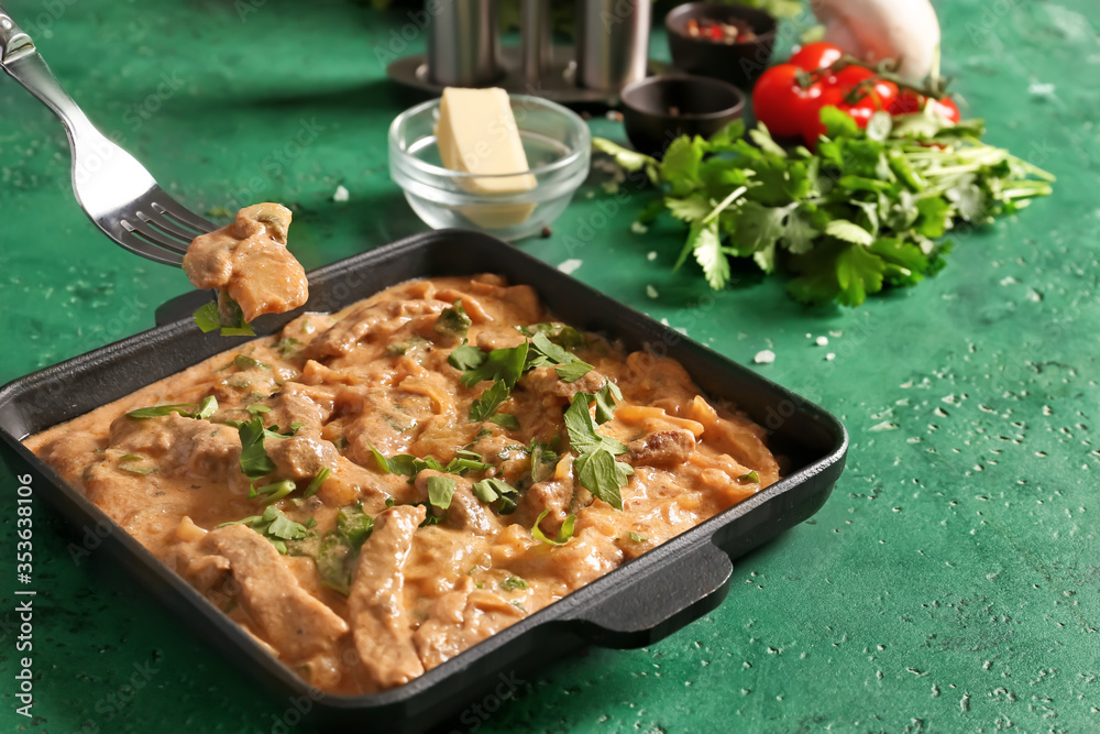 Eating of tasty beef stroganoff on table