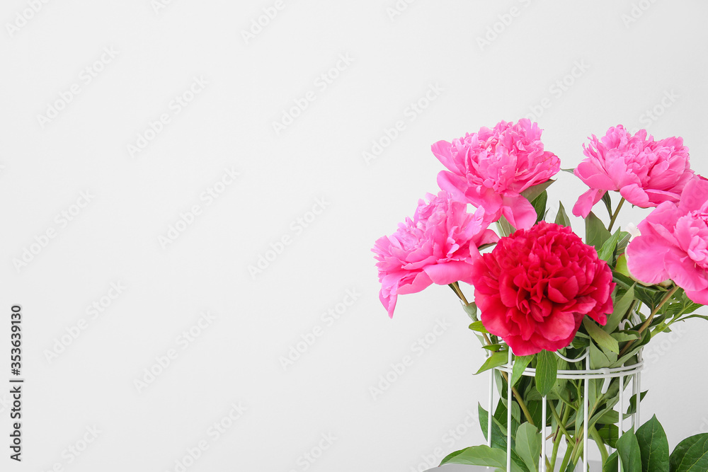 Vase with beautiful peony flowers on light background