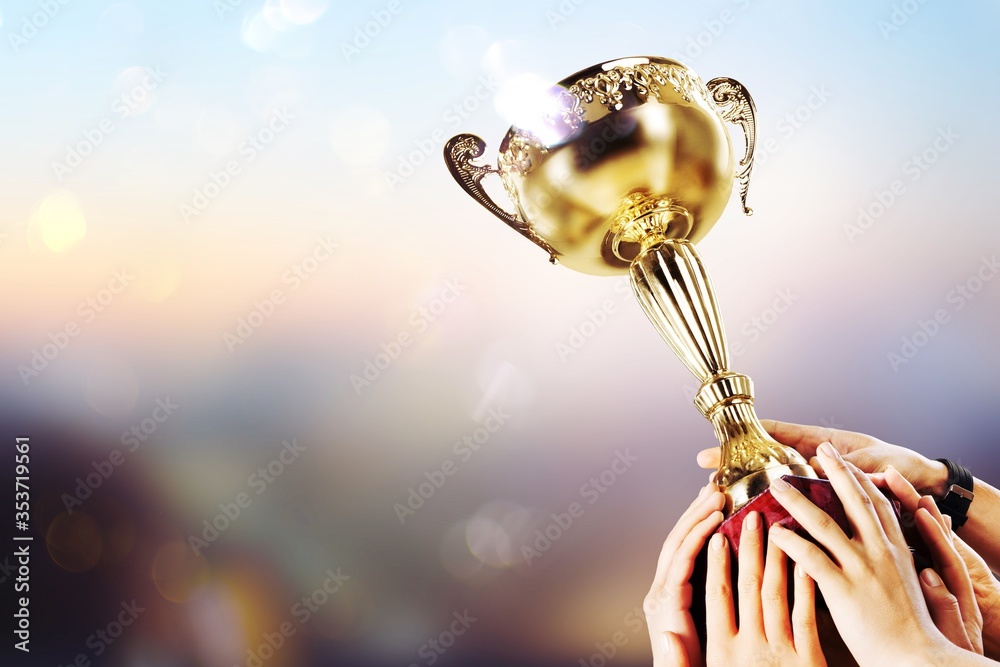 The human hand holds the champion golden trophy. Success concept.