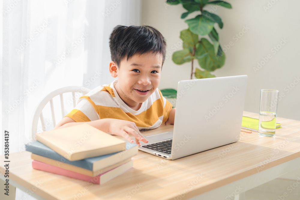 学龄前学生在家里用笔记本电脑学习的照片