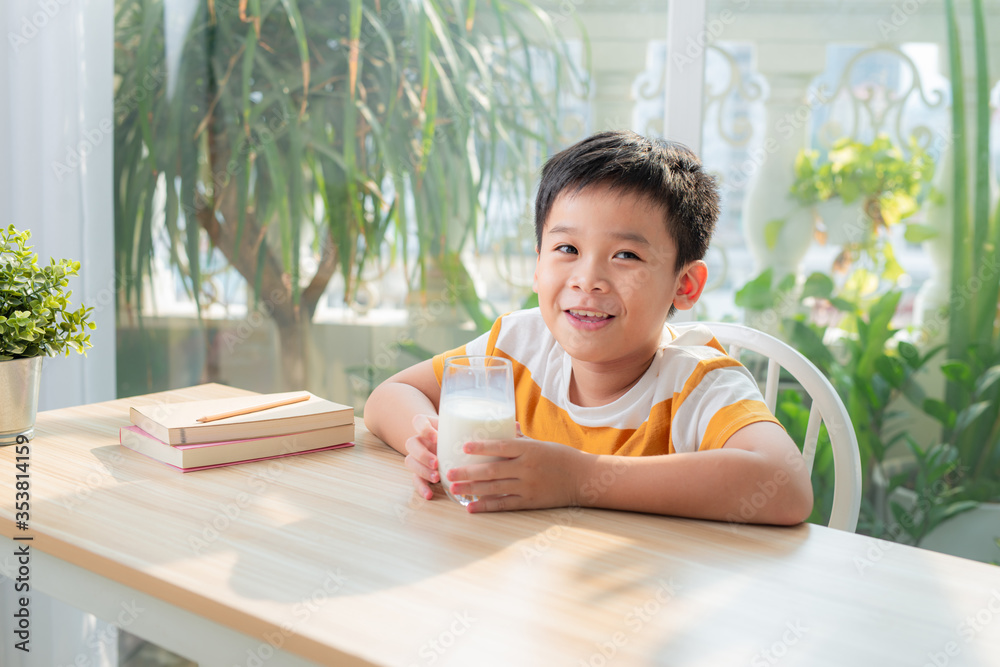 聪明的男孩坐在桌子旁，手里拿着很多书《教育概念》。