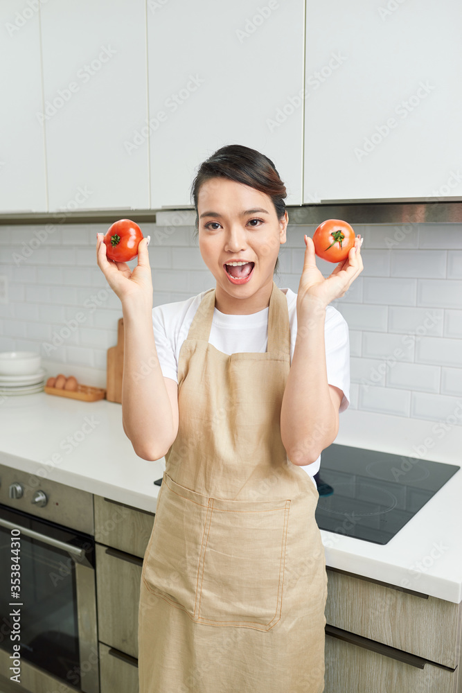 迷人有趣的房子妻子女士抱着两个大番茄嬉戏的心情享受早晨的烹饪美味