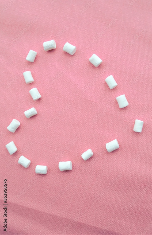 marshmallows heart on a pink linen background