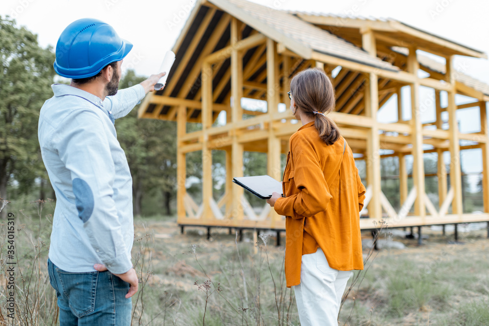 建筑工地户外木屋结构附近有一名女性客户的建筑商。Buil