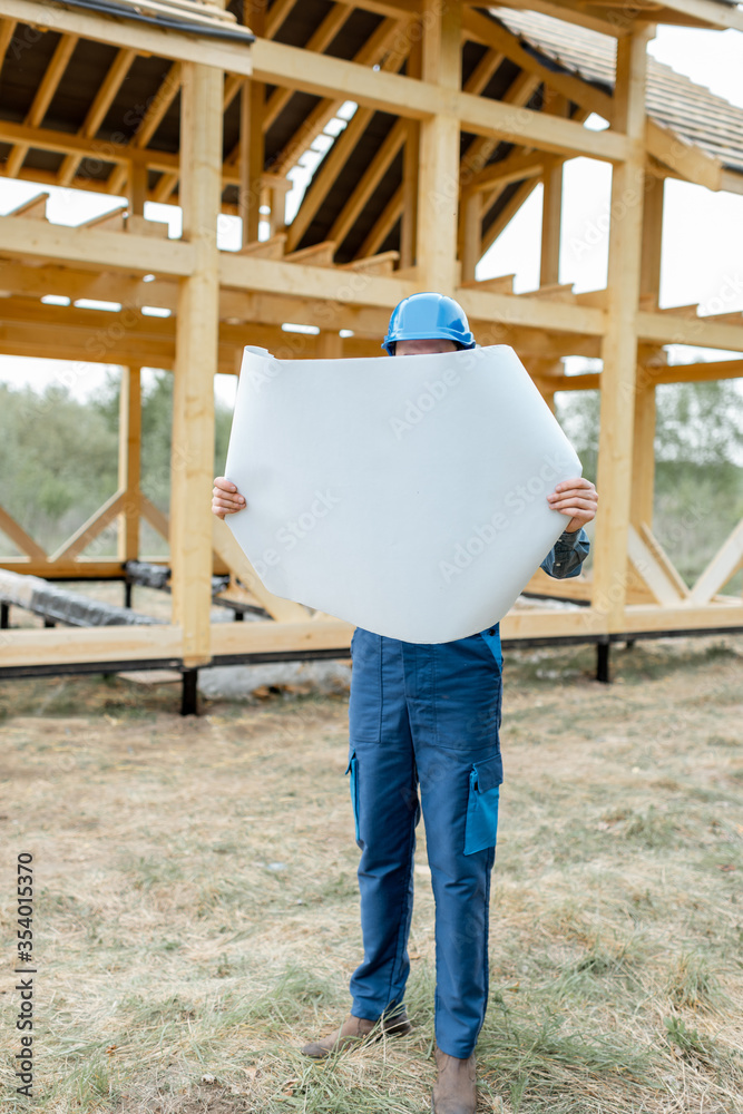 建筑工地上穿着蓝色工作服、戴着安全帽的建筑工人，正在建造木制框架