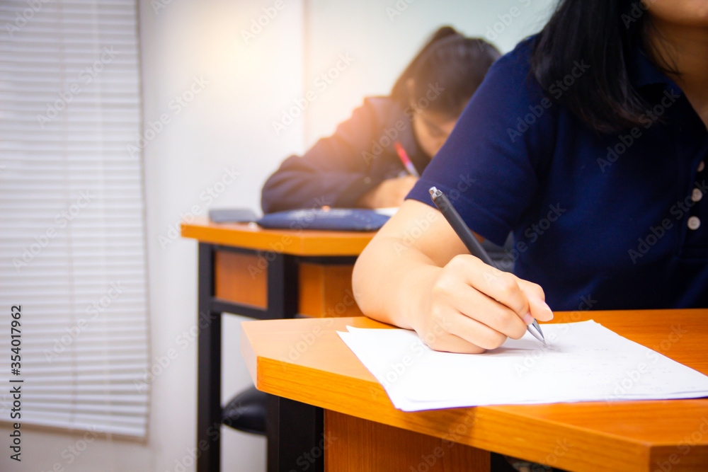 Hands university student holding pen writing /calculator doing examination / study or quiz, test fro