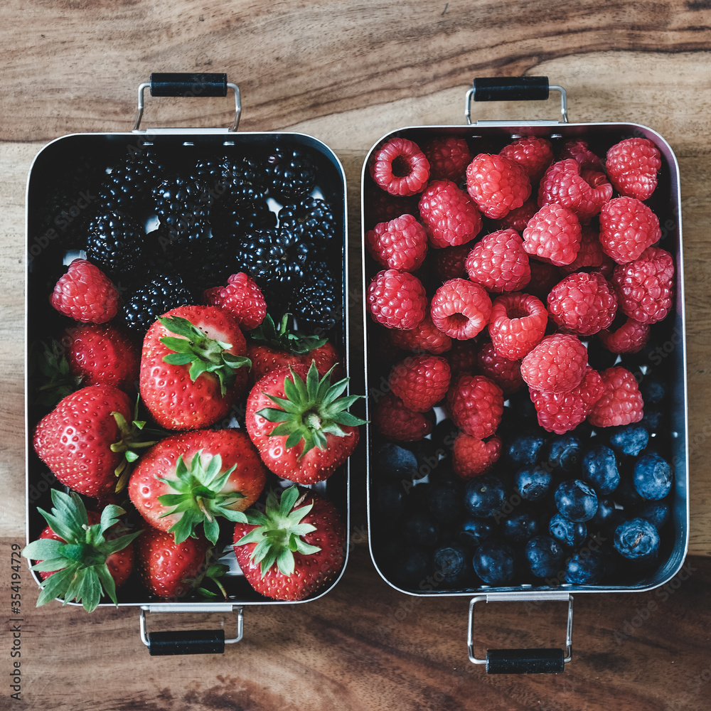 Healthy summer vegan lunch. Flat-lay of fresh seasonal strawberries, raspberries, blueberries and bl