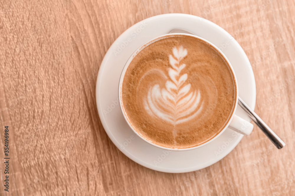 Cup of tasty coffee on wooden table