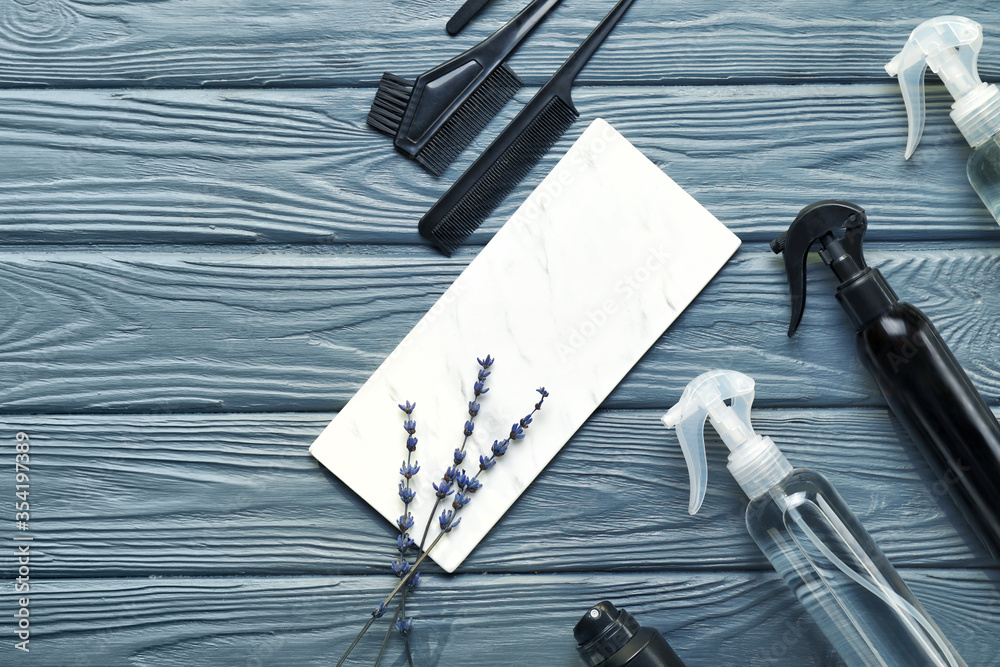 Hair sprays with hairdresser supplies on wooden background