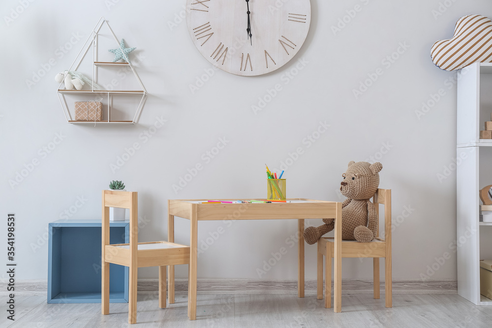 Stylish interior of children room with table and chairs