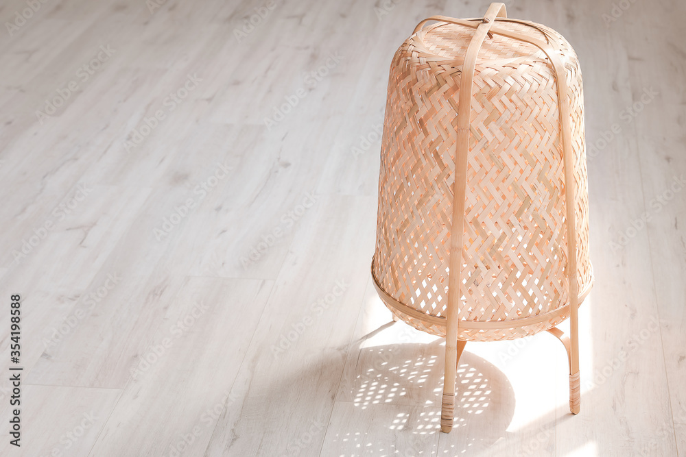 Stylish wicker lantern in room