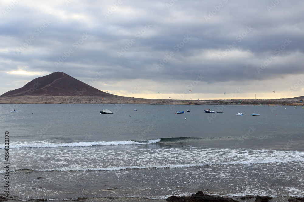 Bay of El Medano panorama with kitesurfers, Atlantic Ocean and dark clouds on Canary Island Tenerife