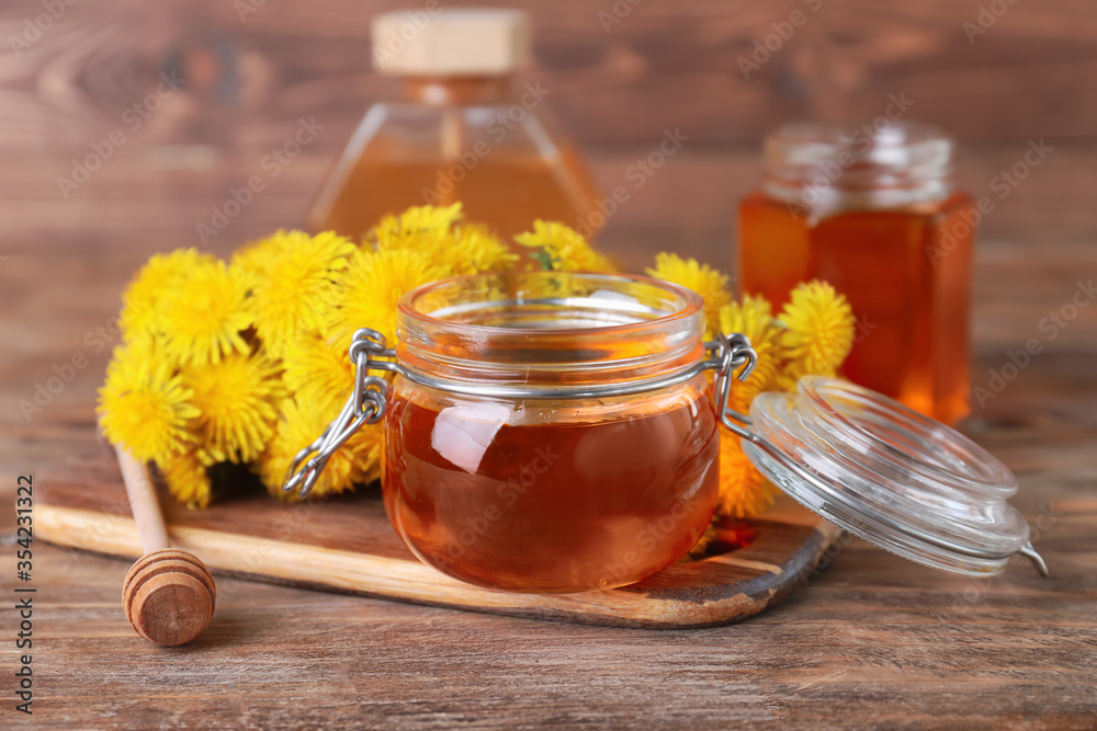 Composition with sweet dandelion honey on wooden background