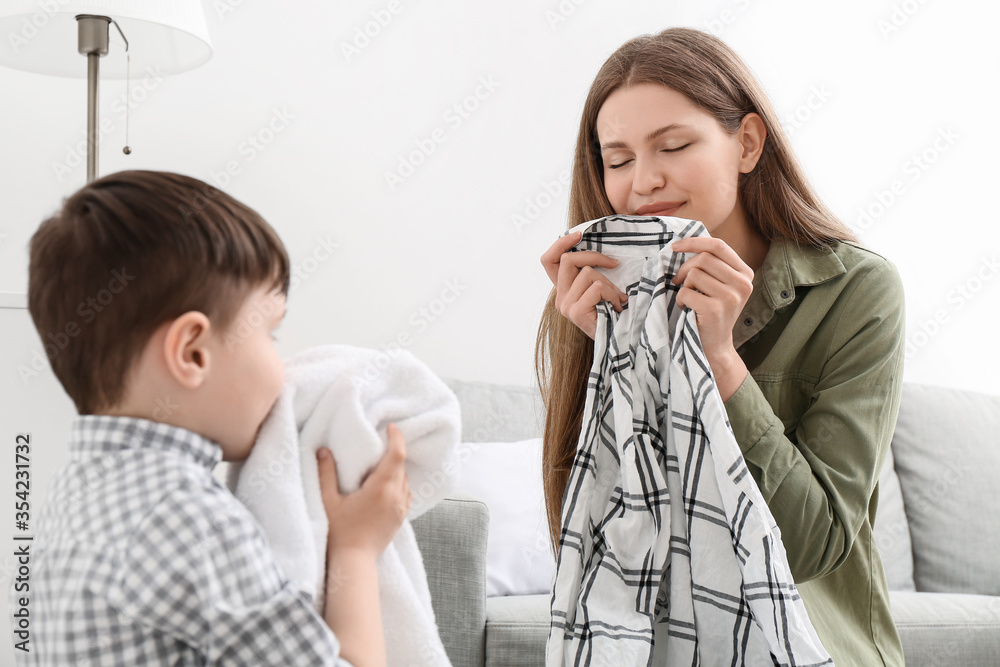 家里有干净衣物的年轻女子和她的小儿子