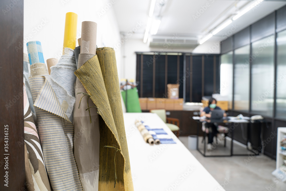 Cloth designer office with rolls of fabric in foreground