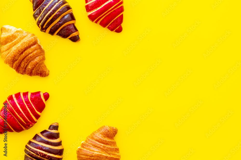 Set of croissants - chocolate, berry, classic - on yellow background top view