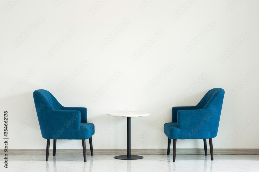 Blue turquoise double armchair with coffee table between armchairs in living room with copy space.