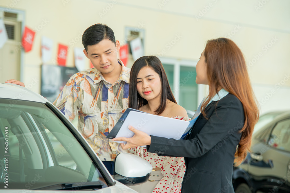 销售人员在汽车展厅销售汽车，客户购买新车概念。