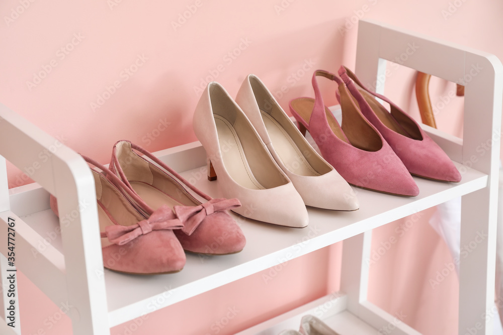 Stand with stylish shoes in interior of modern hall