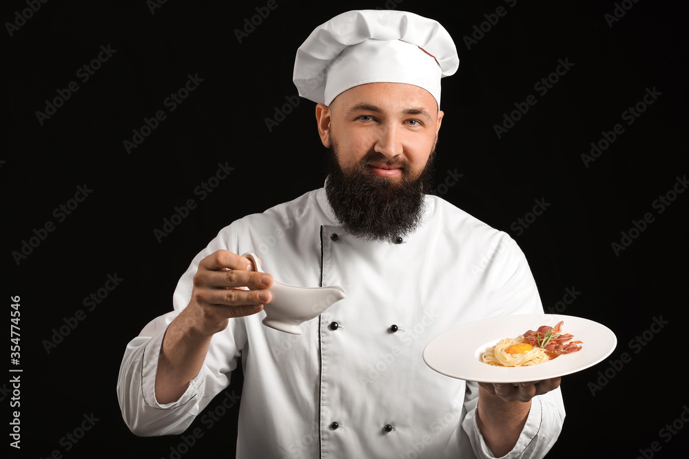 Handsome male chef on dark background