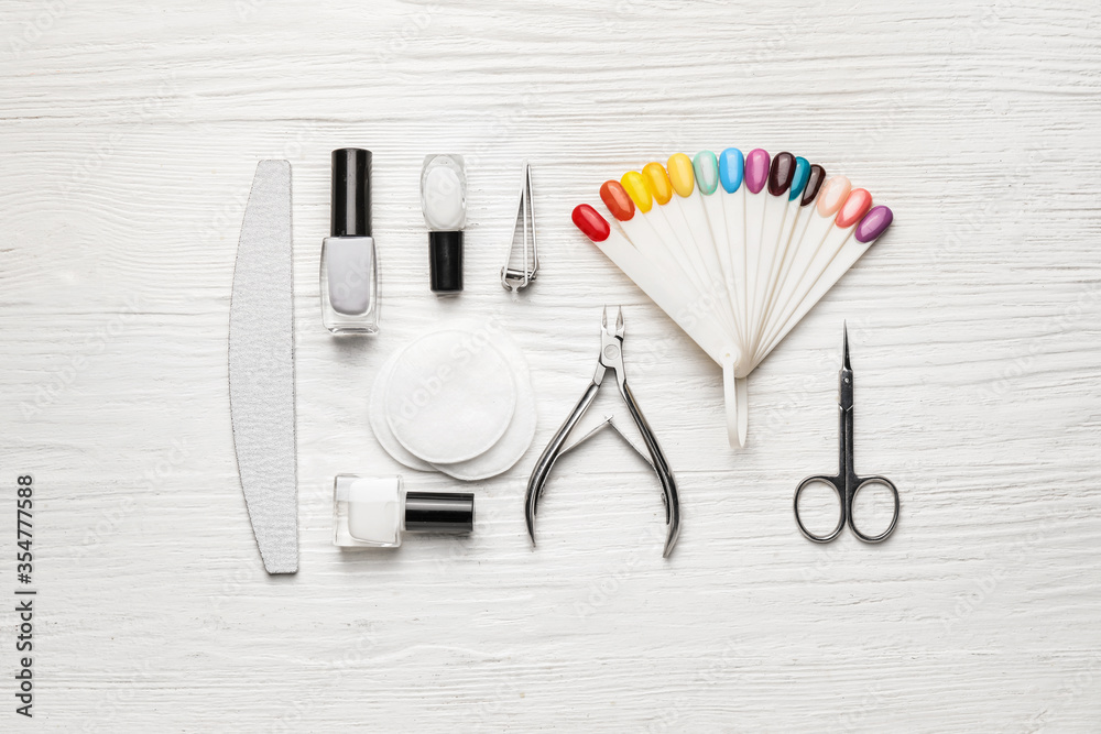 Supplies for manicure on white wooden background