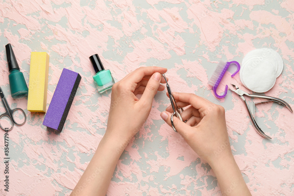 Female hands with supplies for manicure on color background