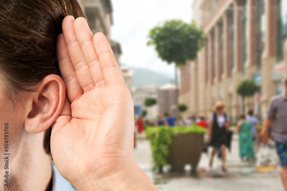 Human holds his hand near his ear and listening