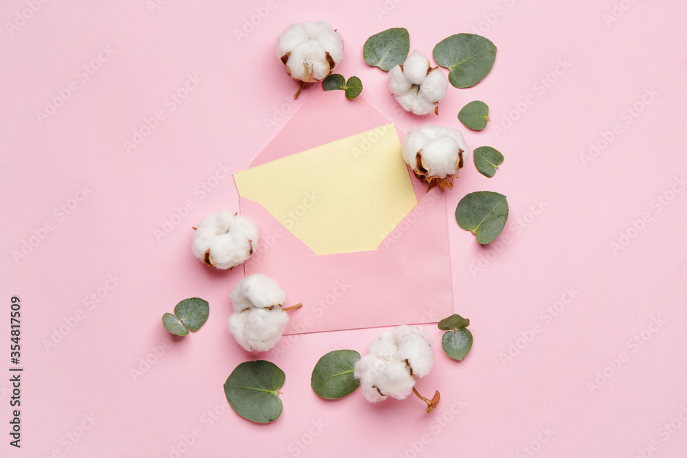 Envelope, beautiful cotton flowers and eucalyptus leaves on color background