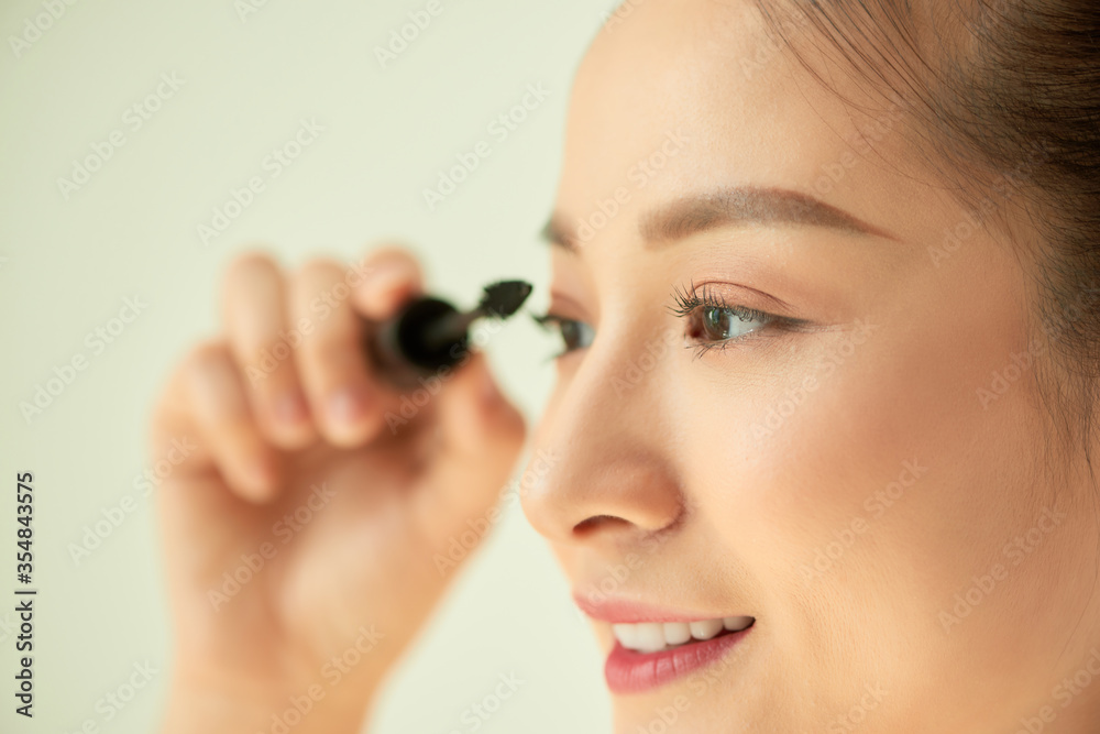 beautiful young woman applied mascara, studio beauty portrait