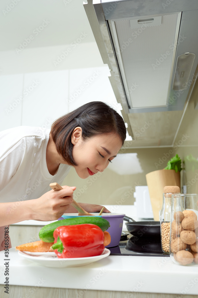 年轻女性在厨房烹饪。健康食品。饮食理念。健康生活方式。在Hom烹饪