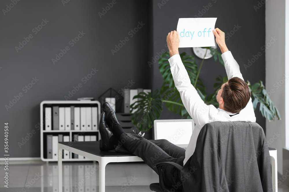 Young businessman dreaming about weekends in office