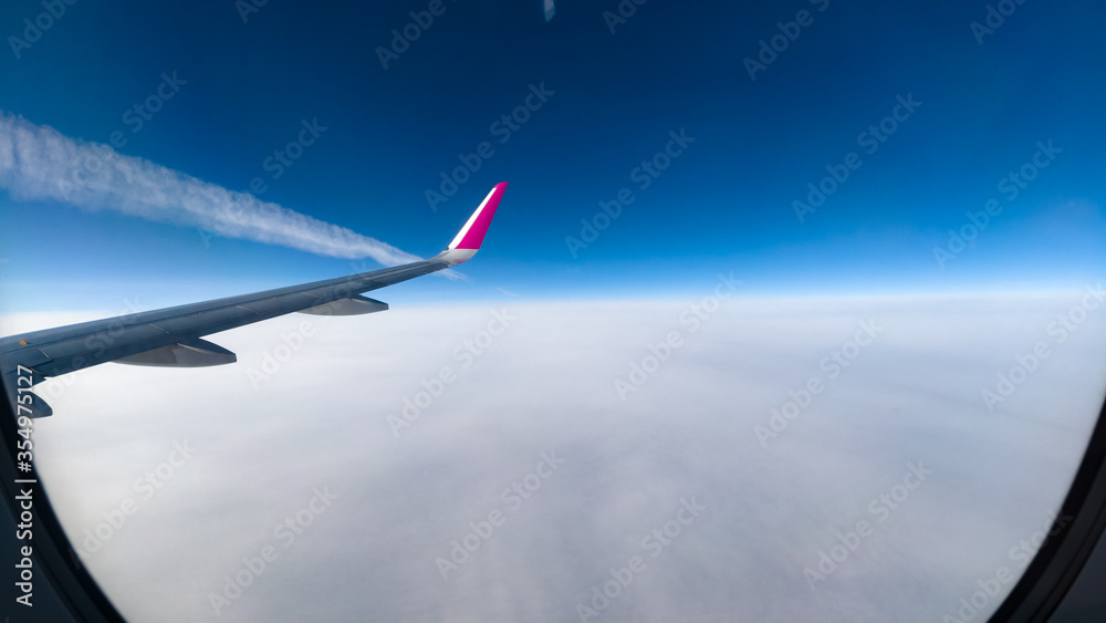 Inversion trail of an airplane above the clouds.