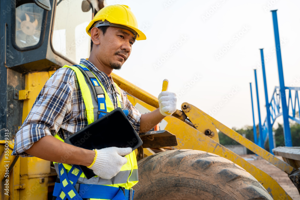 建筑工人在建筑工地的后台带着反铲装载机。